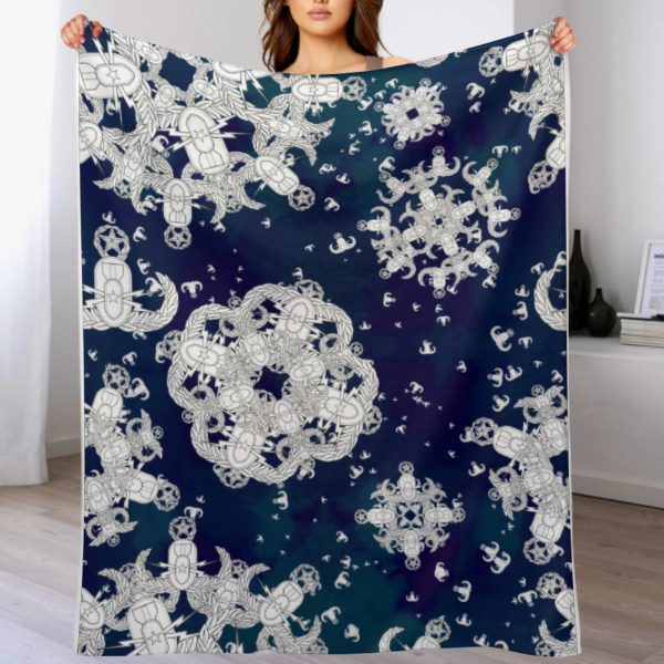 A woman holding up a plush throw blanket with a blue and white pattern of EOD badge snowflakes