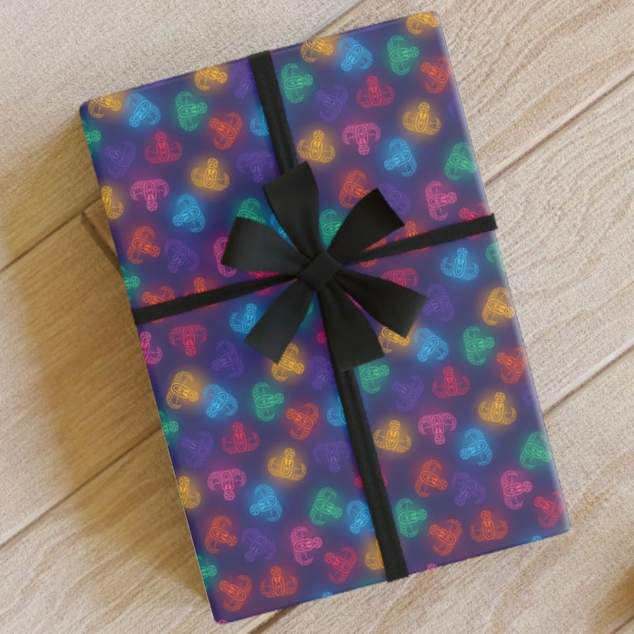 Gift box with colorful heart pattern and black ribbon on a wooden floor.