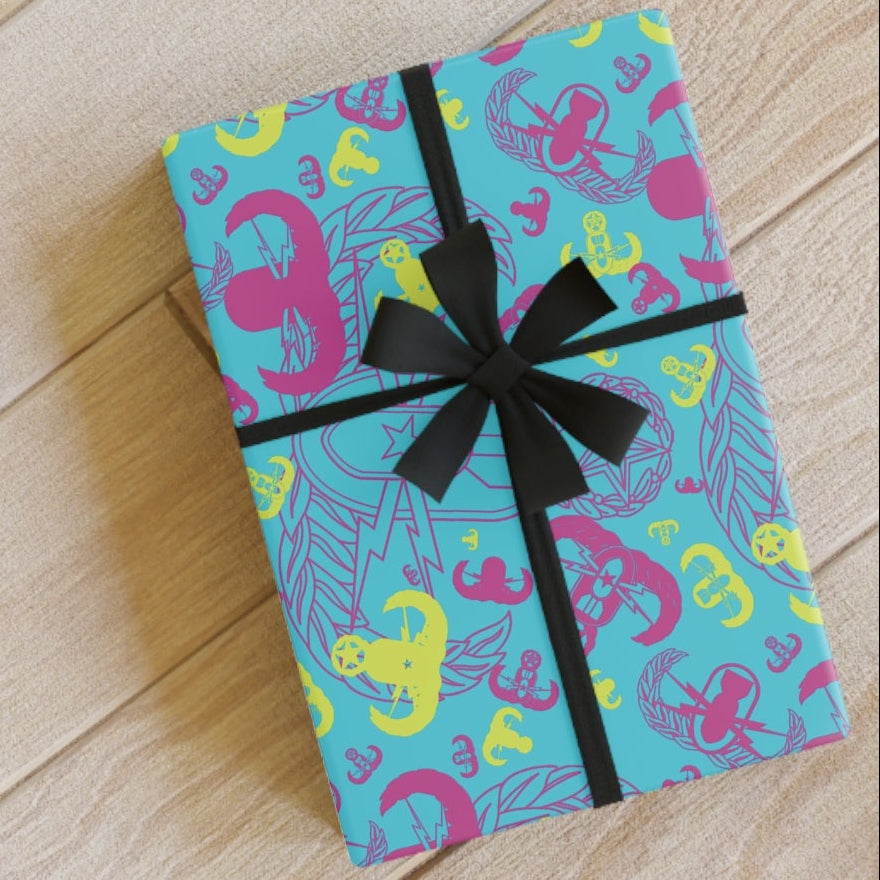 Gift box with colorful wrapping paper and black ribbon on a wooden floor.