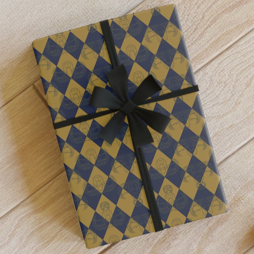 Checkered envelope with black ribbon on a wooden surface with scissors and pencils.