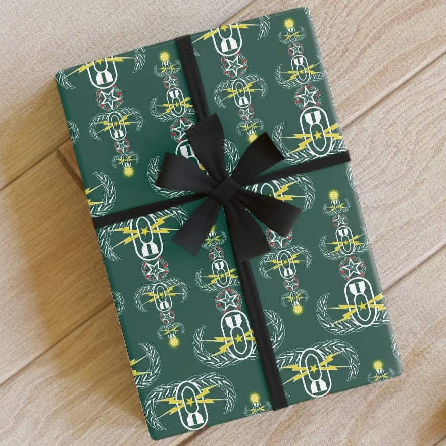 Gift box with green pattern and black ribbon on a wooden floor