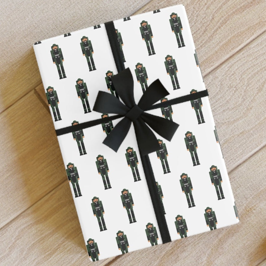 Gift box with black ribbon on a wooden floor with scissors and pencils.