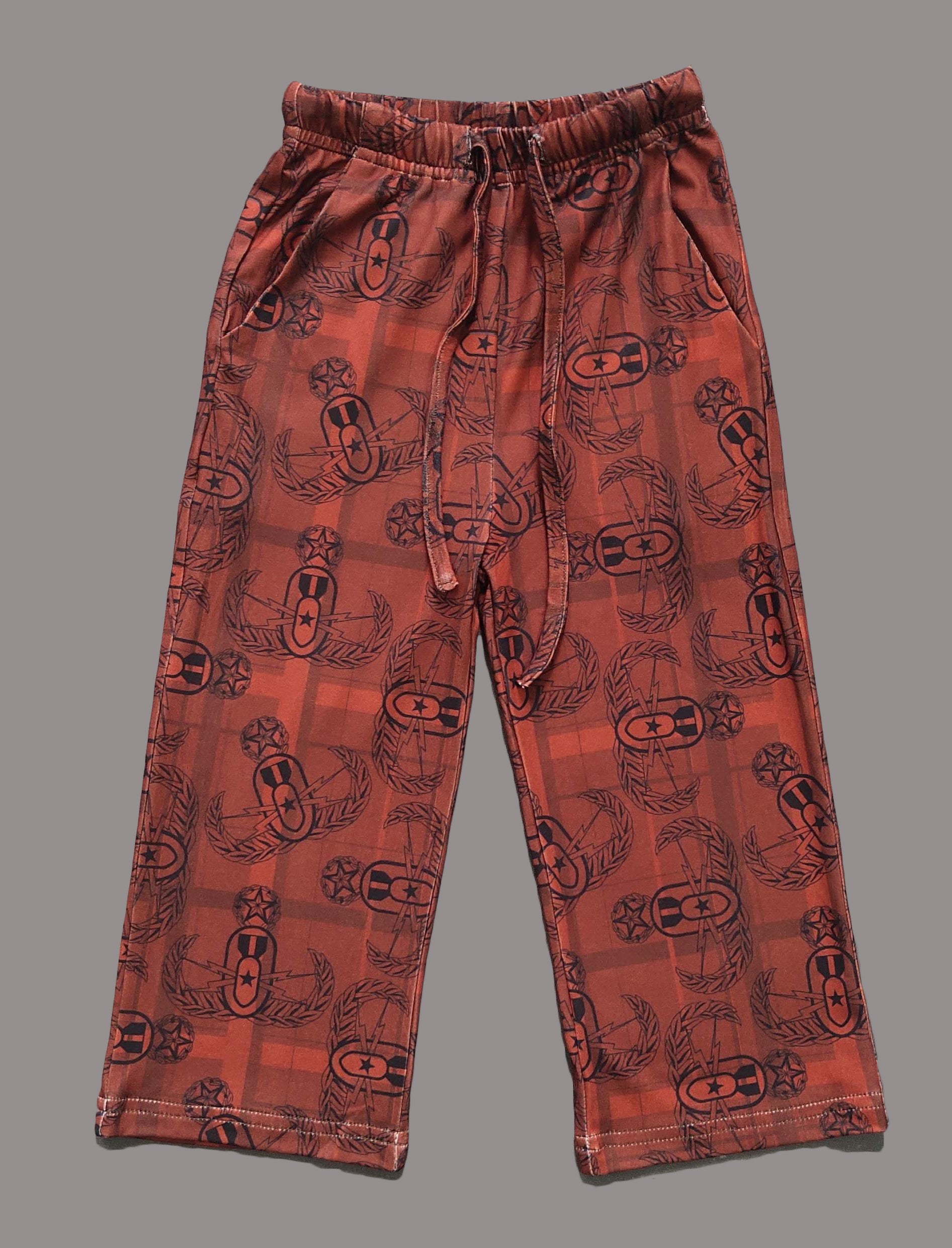 a flat lay of a pair of youth sized red and black EOD Master Badge Plaid pajama pants with pockets and drawstring-elastic waistband on a solid grey background