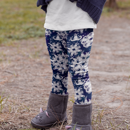 close up of a child's legs, wearing high waisted yoga style leggings with a blue and white pattern of EOD badge snowflakes, outside  with her boots and a sweater on